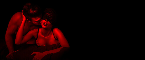 Sexy woman in lace eye cover in red light with young lover - 506137069