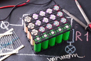 Lithium battery pack in black plastic holder on dark background.