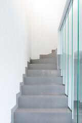 A modern staircase. Marble staircase and glass railing.