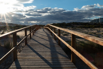 A wooden bridge between the dunes. The sunset. - 506138077