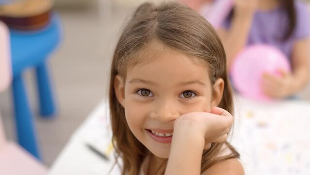 Happy little girl smile and her show hand with another friends background in classroom,kindergarten education school.Multi-ethnic preschool teacher and students in classroom.Kindergarten concept.