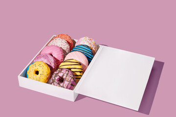 Decorated donuts in a box on yellow background