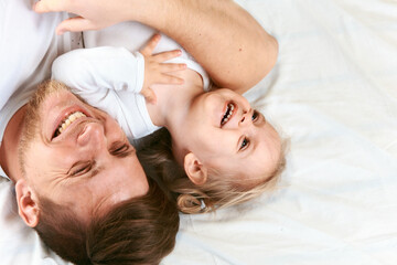 Happy relationship of handsome dad and cute daughter. Father is playing with toddler girl. Dad...