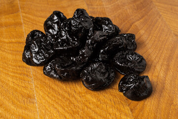 Dried dried prunes in a heap on a wooden board