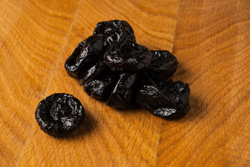 Dried dried prunes in a heap on a wooden board