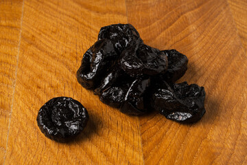 Dried dried prunes in a heap on a wooden board