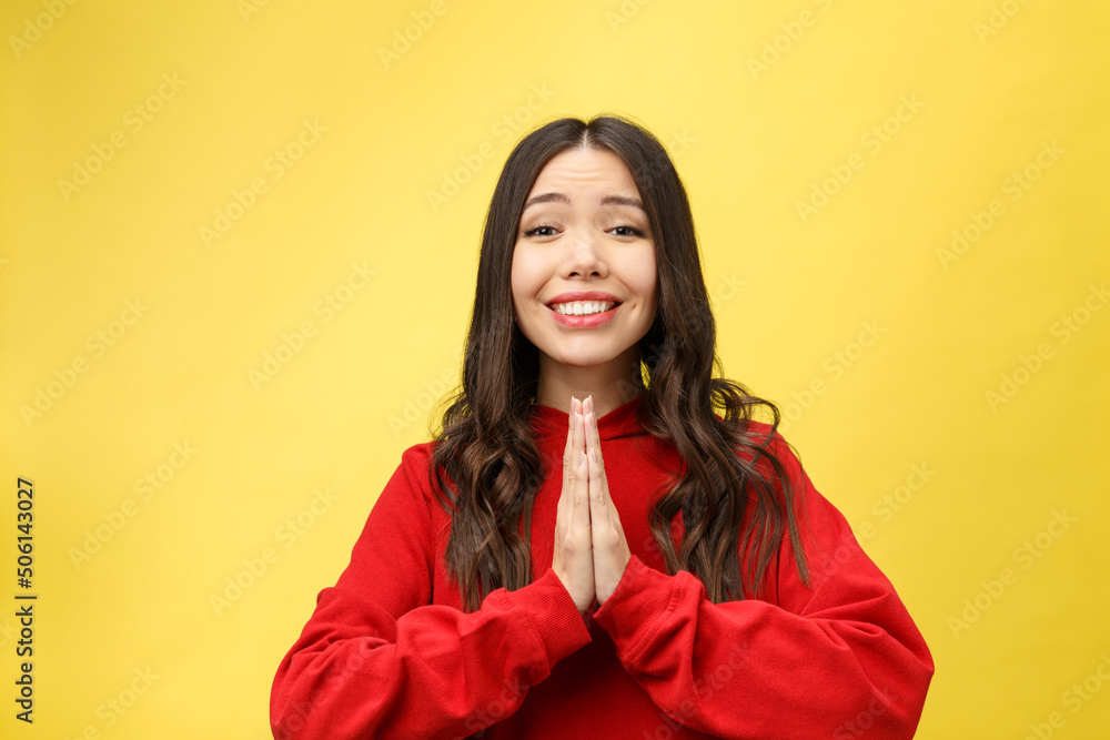 Wall mural Getting concentration from space. Portrait of good-looking young european female, holding hands in pray, focused on wishing over yellow background