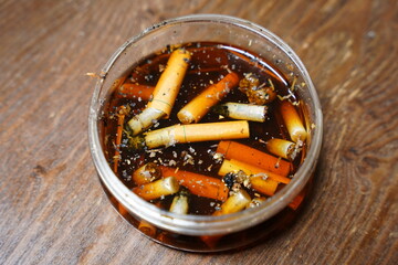 Cigarettes are left in dirty tare water after use.