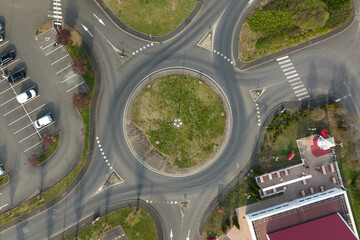 Aerial view of road roundabout intersection with fast moving heavy traffic. Urban circular...