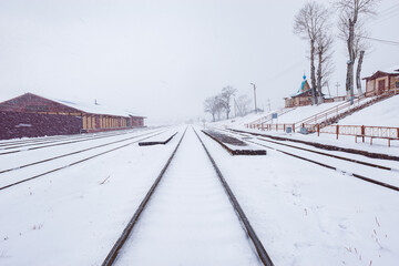 Railway tracks of the station under the snowfall.
