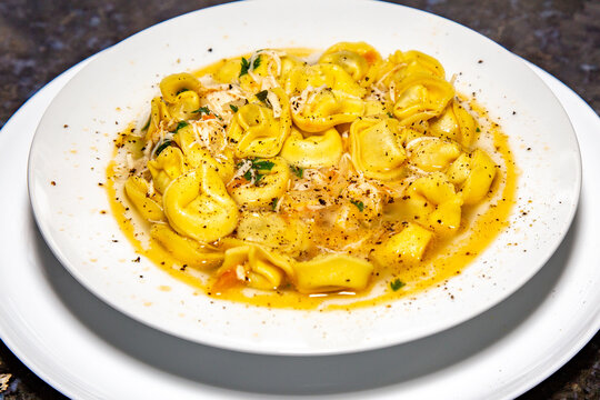 Italian tortellini (capeletti, agnolini) soup with chicken and vegetables, special soup for cold nights. In fine details