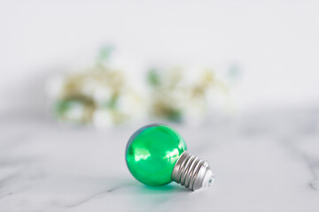green economy and ideas for the environment, green light bulb idea with frangipani flowers in the background