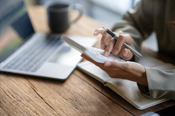 Businessman or accountant working on calculator to calculate business data concept. Accounting,investment advisor consulting situation on the financial report and planning a marketing plan at office