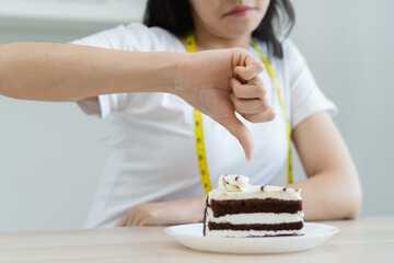 eat less sugar for health, women avoid to eat chocolate cake and sweets during sugar diet session...