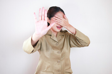 portrait of an Asian woman wearing a brown uniform scared. Indonesian government employees uniform.