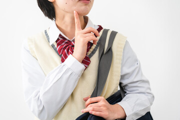 指を顎に当てて考える女子高校生