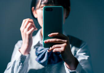 スマートフォンを見て不安になる女子高校生
