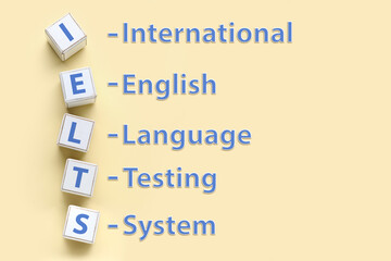 Text INTERNATIONAL ENGLISH LANGUAGE TESTING SYSTEM and cubes on color background