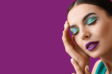 Beautiful young woman with stylish unusual makeup on violet background with space for text - obrazy, fototapety, plakaty
