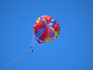 Woman parasailing high up in the sky