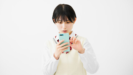 スマートフォンを操作する女子高校生