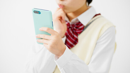スマートフォンを持って困惑する女子高校生