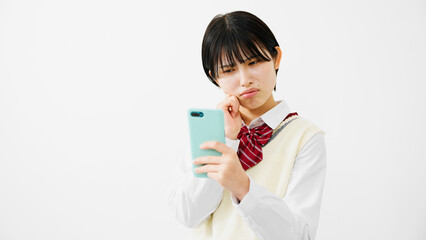 スマートフォンを持って困惑する女子高校生