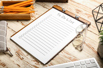 Clipboard with blank to do list, eyeglasses and pencils on light wooden background, closeup