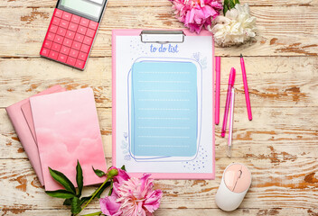 Composition with blank to do list, stationery and flowers on light wooden background