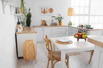 Interior of light stylish kitchen with comfortable dining table
