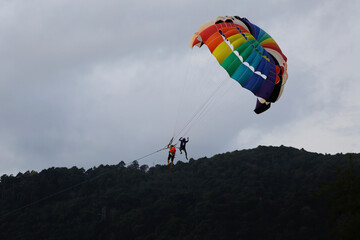 People practice parasailing in Patong beach, Phuket, southern Thailand. Thai government is accelerating the completely reopen of the country to foreign tourists amid COVID-19 in 2022.