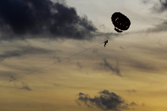 People practice parasailing tied to a boat in Patong beach, Phuket, southern Thailand. Thai government is accelerating the completely reopen of the country to foreign tourists amid COVID-19 in 2022.