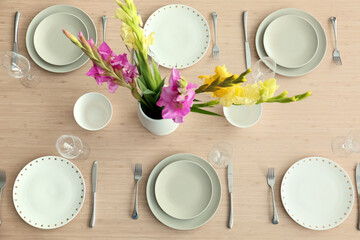Stylish table setting with beautiful Gladiolus flowers