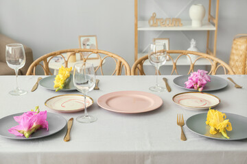 Dining table with beautiful setting and Gladiolus flowers in room