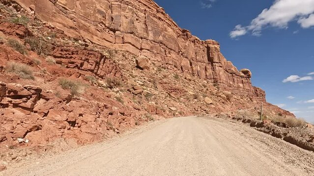 Moki Dugway Utah desert mountain POV part 1. Roadway carved from a mountain cliff. Scenic Backway dirt road drastically switches backs the side of cliff very narrow. Built as mining and uranium road.