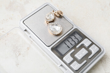 Jewelry scales with earring on light background