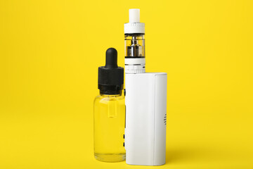 Modern vape mod and oil on yellow background