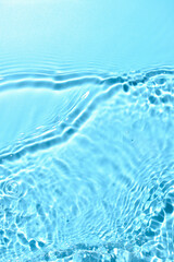 Fototapeta na wymiar Texture of water with ripples on blue background, closeup