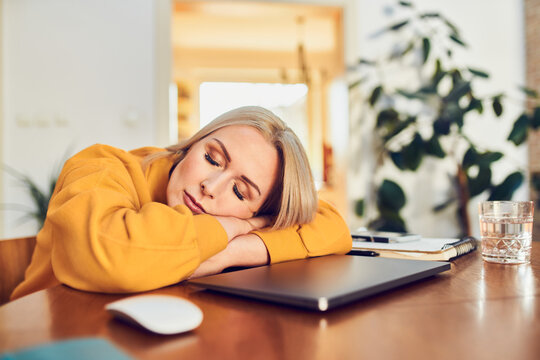 Closeup of tired woman sleeping on table while working remotely