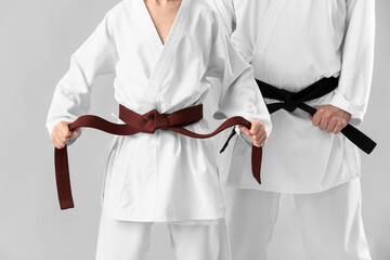 Boy with karate instructor on light background © Pixel-Shot