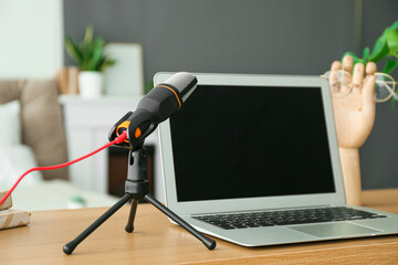 Modern microphone and laptop on table