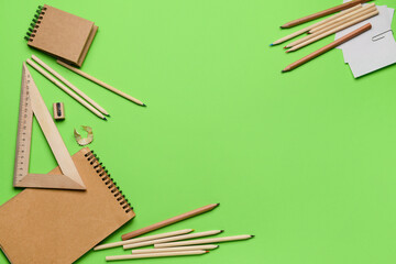 Frame made of stationery supplies on green background
