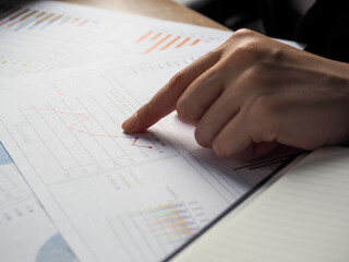 business woman pressing finger on graph on document Financial audit of the company. Sales growth of the business.