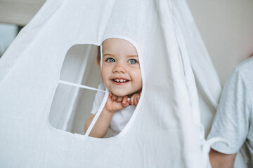 Cute funny baby girl having fun in wigwam in children room at home © Galina Zhigalova
