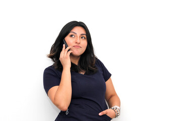 Latin young adult woman uses her cell phone to send and receive messages and video calls with gestures of emotion and anger
