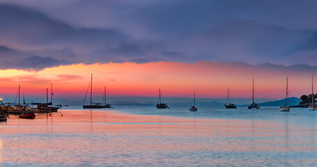 Sailing yacht parked in Datca bay and peninsula with Stormy clouds in the background at sunrise -...