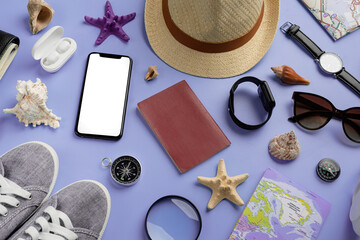 Fototapeta na wymiar Top view travel accessories with shoes, map, smartphone with mockup screen, hat on very peri purple background