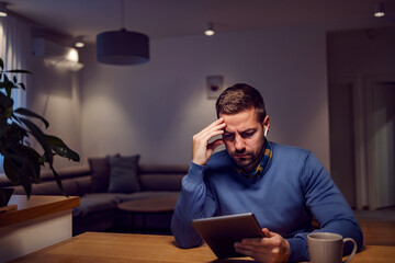 A focused man watching educative videos on the tablet at home.
