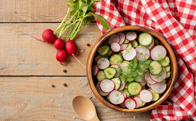 Bowl of healthy vegetarian salad with raddish cucumber and fennel. top view on wooden background with copy space