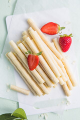 Heap of waffle rolls isolated on white background with strawberry